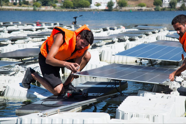 A technician installing and fixing Floating Solar Panels on a water body depicting Operations and Maintenance at solar energy company Aegis Renewable Tech Solutions Pvt. Ltd., Kolkata, India.